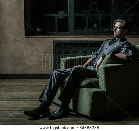 Businessman sitting on an armchair. Fahion man.