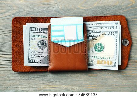 Hand made leather man wallet with money on wooden background
