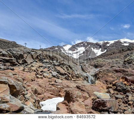 Mount Ruapehu landscape and small watefall flowing under a snow cap in Tongariro National park