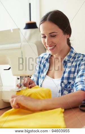 sempstress working with sewing machine and smiling 