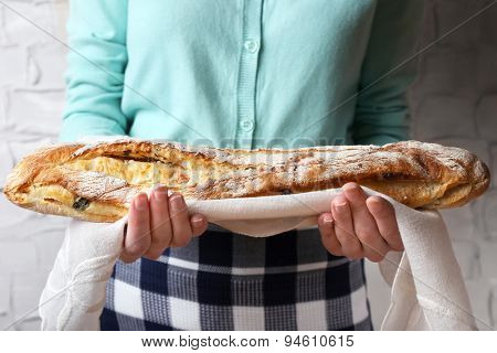 Woman holding tasty fresh bread, close up