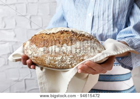 Woman holding tasty fresh bread, close up