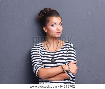 A young woman standing, isolated on graybackground