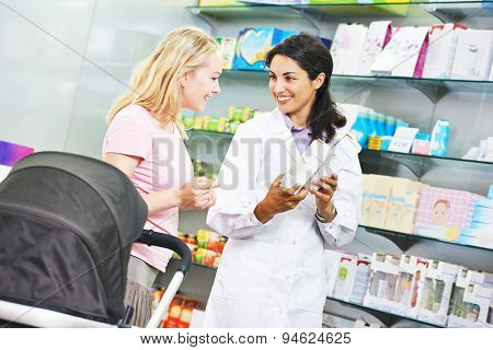 pharmacist chemist woman helps to choose medicine for young to female buyer in pharmacy drugstore