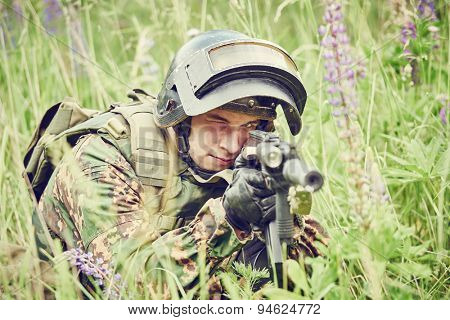 military. soldier in uniform targeting with assault rifle outdoors