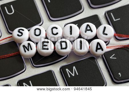 Social media letter beads on laptop keyboard keyboard concept for social networking, blogging, marketing and youth culture