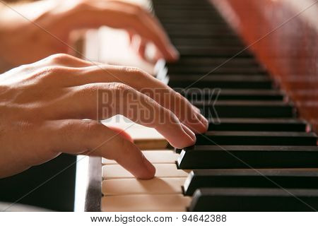 Close-up of hands playing the piano