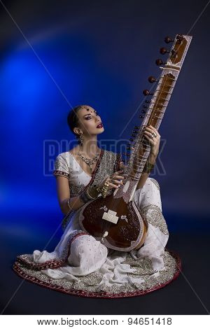 Beautiful Indian Woman In Sari With Oriental Jewelry Playing The Sitar