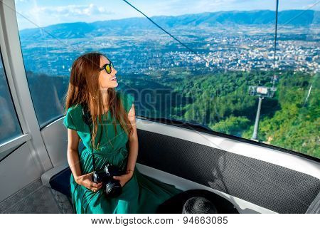 Woman in cable car with cityscape view