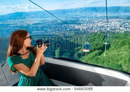 Woman in cable car with cityscape view