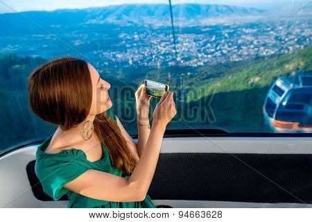 Woman in cable car with cityscape view