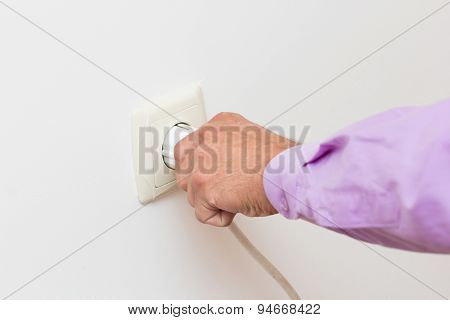 Hand Putting Plug Into Electricity Socket