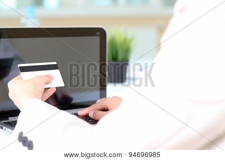 Young Business Woman  Entering  Data Of  A Credit Card . On-line Shopping On The Internet Using A La