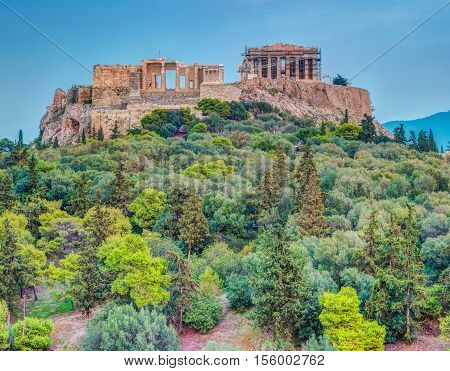 Parthenon and Herodium construction in Acropolis Hill in Athens, Greece. Beautiful landscape with green trees around ancient architecture.