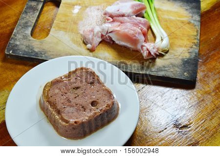 dog premium wet food and fresh raw pork on chop block