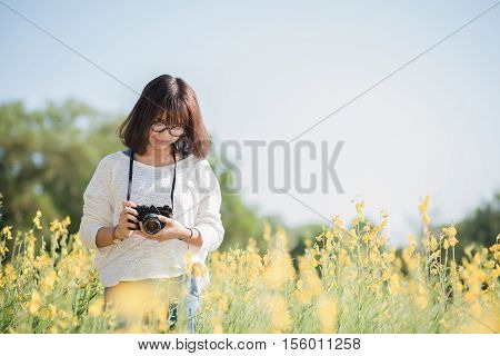 Young woman with camera in the Sunhemp garden