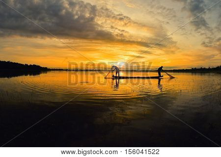 Fishermen out fishing with nets in the morning sunrise.
