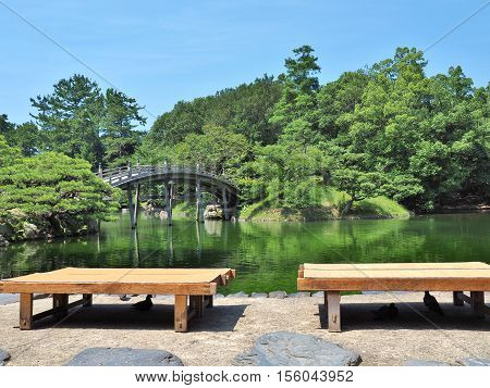 Wooden benches and wooden bridge - Engetsukyo in Ritsurin Garden in Takamatsu city, Kagawa Prefecture, Japan. Ritsurin Garden is one of the most famous historical gardens in Japan.