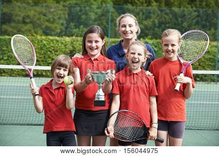 Portrait Of Victorious School Tennis Team With Trophy