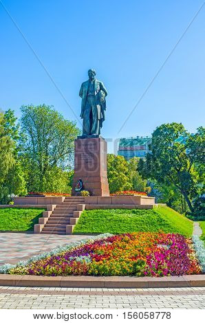 The monument of Taras Shevchenko the most famous Ukrainian poet writer and painter surrounded by colorful flowers and lush trees of park Kiev Ukraine.