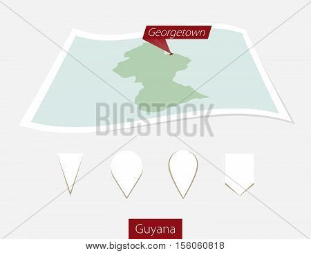 Curved Paper Map Of Guyana With Capital Georgetown On Gray Background. Four Different Map Pin Set.