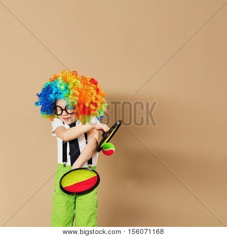 Blithesome Children. Portrait Of Happy Clown Boy Wearing Large Neon Coloured Wig