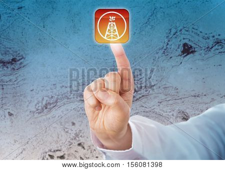 Close up of male index finger of a white collar worker pressing an oil and gas drilling push button. Petroleum and heavy industry metaphor for oil and gas well wellbore and drilling technology.