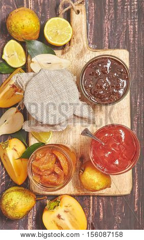 Berry and fruit jam with ingredients on a dark rustic background. Toned photo. Top view