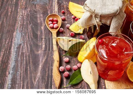 Berry and fruit jam with ingredients on a dark rustic background. Copy space top view.