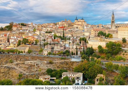 Old city of Toledo with Primate Cathedral of Saint Mary, churches of San Ildelfonso, San Roman and Santo Tome at sunset, Castilla La Mancha, Spain. Restoration of the Arab baths in the foreground