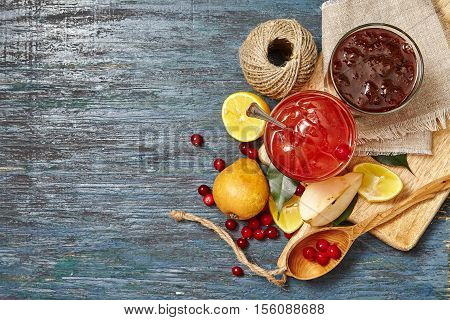 Berry and fruit jam with ingredients on a dark rustic background. Copy space top view.