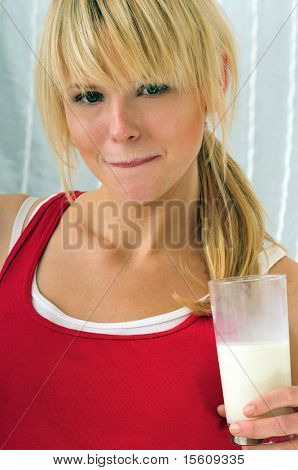 belle femme blonde, boire un verre de lait et d'avoir un milksop
