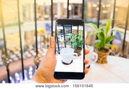 Taking photo of empty white cup with mobile phone