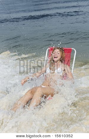 snapshot: donna ridendo sulla spiaggia sorpresa dalle onde dell'oceano