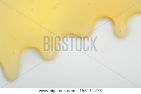 Honey liqiud flowing down on white background