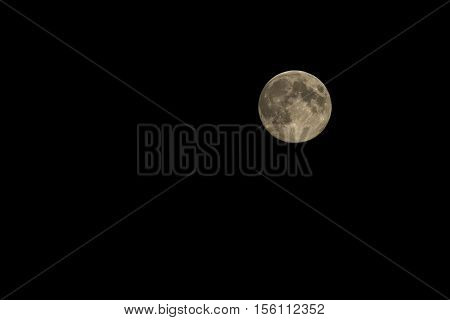 bright yellow full moon against the black night sky