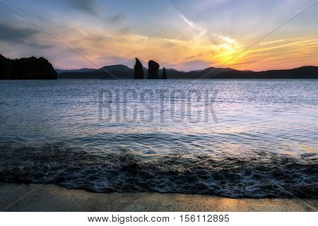 Kamchatka seascape: picturesque view of sunset over Three Brothers Rocks in Avacha Bay (Avachinskaya Bay). Kamchatka Peninsula Russian Far East Pacific Ocean.