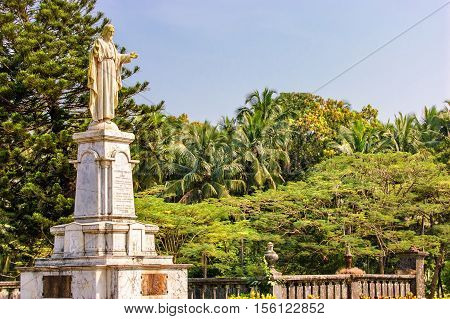 Statue of Jesus in Se Cathedral church around palm trees in Panaji Old Goa India