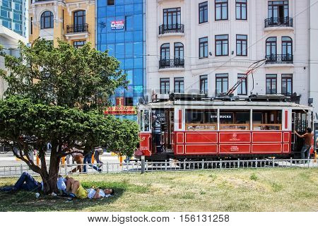 Turkey Istanbul Istiklal Street - June 2015: people rest on city streets. Houses and red tram in the background .