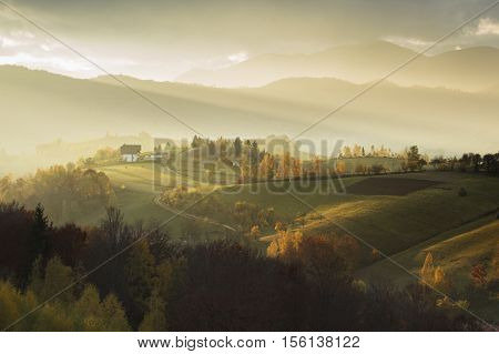 Hills and mountains bathed in warm sunset light in Transylvania, Poiana Marului.