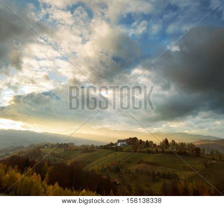 Wide view of hills and mountains bathed in warm sunset light in Transylvania, Poiana Marului.