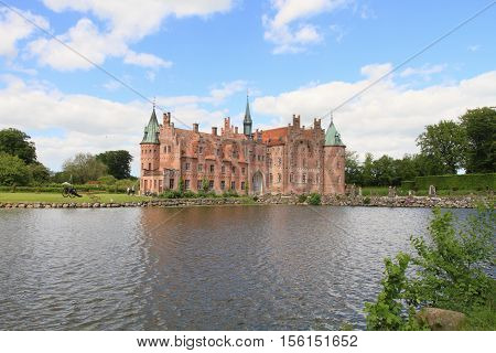 FUNEN, DENMARK - JUNE 4, 2010: Egeskov castle and lake on June 3, 2010 in Funen, Denmark. It is a landmark fairy tale castle in Denmark.