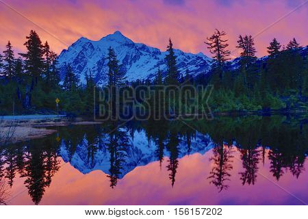 Mountains reflecting in calm waters of lake during sunrise