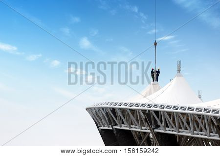 Steel roof construction sites workers at height.