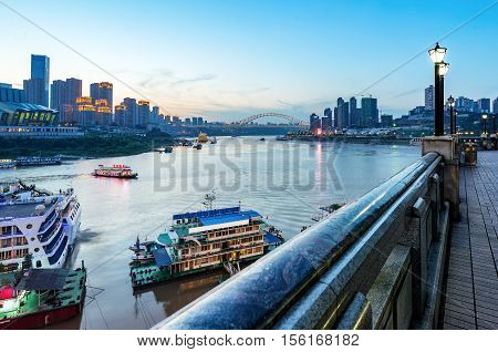 cityscape and skyline of downtown near water of chongqing at night