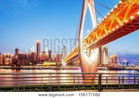cityscape and skyline of downtown near water of chongqing at night