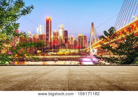 cityscape and skyline of downtown near water of chongqing at night