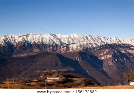 Plateau of Lessinia Regional Natural Park of Lessinia Veneto Verona Italy. In the background the Italian Alps (Monte Baldo - Baldo Mountain)
