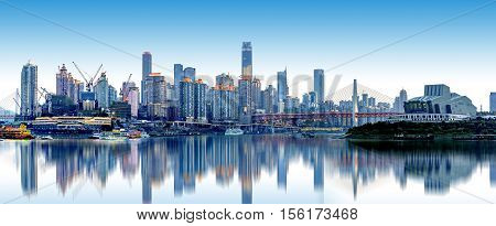 cityscape and skyline of downtown near water of chongqing at night