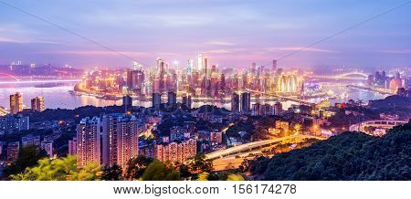 cityscape and skyline of downtown near water of chongqing at night